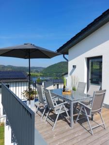 Un patio con una mesa y sillas y una sombrilla. en Sonnenweg 29, en Diemelsee
