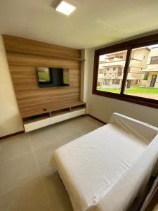 a bedroom with a bed and a large window at Recanto Brisas de Imbassaí Village C18 in Mata de Sao Joao