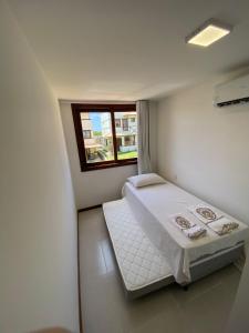 a small room with a bed and a window at Recanto Brisas de Imbassaí Village C18 in Mata de Sao Joao +13 photos