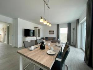 Un comedor y una sala de estar con mesa y sillas. en Sonnenweg 48-4 SAUERLANDBLICK, en Heringhausen
