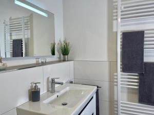 Un baño blanco con lavabo y espejo. en Sonnenweg 48-4 SAUERLANDBLICK, en Heringhausen 14 fotos más