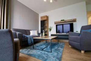 a living room with couches and a table and a tv at Sonnenweg 46-6 WILDE 13 in Heringhausen
