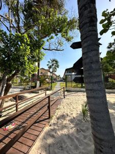 a palm tree in the sand next to a fence at LENÇOIS VILLE RESIDENCE in Barreirinhas
