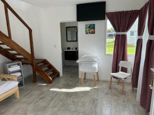 ein Raum mit einer Treppe und einem Tisch und Stühlen in der Unterkunft Complejo Las Cabañas del Lago in Mar de Cobo