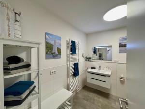 Un baño blanco con lavabo y espejo. en Sonnenweg 48-6 MIRO, en Heringhausen 20 fotos más