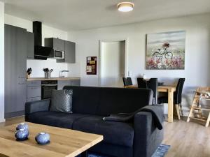 Una sala de estar con un sofá azul y una mesa. en Sonnenweg 46-2 CINDY, en Heringhausen