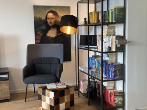Una habitación con una silla y una estantería con libros. en Sonnenweg 48-5 - HARMONIE, en Heringhausen 4 fotos más