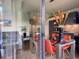 a dining room with orange chairs and a table at Dahmer Strand 7 in Dahme