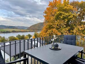 a table on a balcony with a view of a river at Sonnenweg 18 in Heringhausen