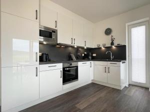 a white kitchen with white cabinets and appliances at Sonnenweg 18 in Heringhausen