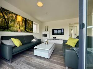 a living room with a green couch and yellow pillows at Sonnenweg 18 in Heringhausen