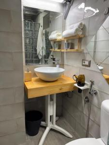 a bathroom with a white bowl sink on a wooden table at Attardo's House in Catania