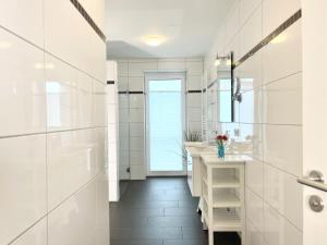 a white bathroom with a sink and a mirror at Quartier Hohe Geest 22 in Cuxhaven +23 photos
