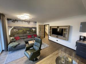 a living room with a couch and a television at Sonnenweg 31 - HAUS DIEMELSEE in Heringhausen