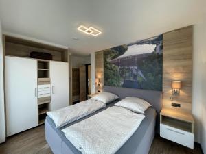 a bedroom with two beds and a painting on the wall at Sonnenweg 31 - HAUS DIEMELSEE in Heringhausen