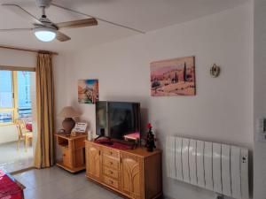 Una sala de estar con un televisor de pantalla plana sobre una cómoda. en Casita Bonita, en Calpe