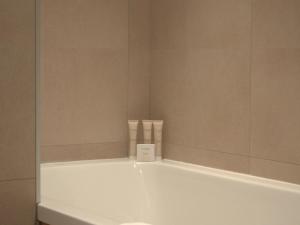 a white bath tub in a bathroom with a mirror at Charmant T4 rénové proche pistes, parking, Wifi - FR-1-575-33 in Courchevel