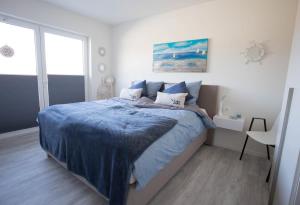 ein Schlafzimmer mit einem Bett mit einer blauen Decke in der Unterkunft Diemelblick 1 in Heringhausen