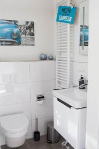 ein weißes Badezimmer mit Toilette und Waschbecken in der Unterkunft Diemelblick 1 in Heringhausen + 13 Fotos
