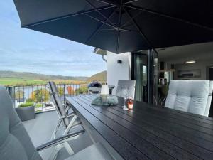 a wooden table with an umbrella on a balcony at Sonnenweg 6 in Heringhausen