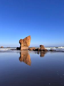 a beach with two large rocks in the water at Apartamento Miravalles in Muros de Nalón