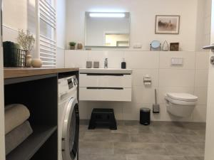 a bathroom with a washer and a sink and a toilet at Sonnenweg 44-3 - HYGGE in Heringhausen +16 photos