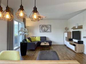 a living room with a blue couch and a tv at Diemelblick 23 - DIEMELTJE in Heringhausen