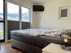 a bedroom with a bed and a large window at Diemelblick 23 - DIEMELTJE in Heringhausen