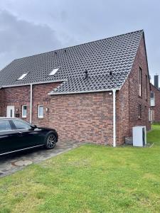 a black car parked in front of a brick building at Am Kutterhafen 8 - Nordic Mood in Fedderwardersiel