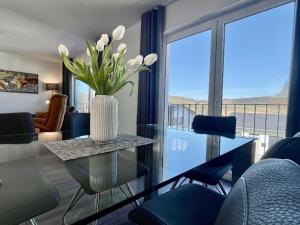 een woonkamer met een vaas met bloemen op een tafel bij Sonnenweg 11 in Heringhausen