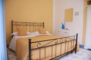 a bedroom with a large bed with yellow walls at Villa Lery - Azzurra Home in Agropoli +15 photos