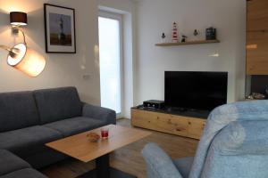 a living room with a couch and a television at Am Kutterhafen 3 - PIER 3 in Fedderwardersiel