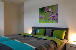 a bedroom with a bed with green and blue at Ferienhaus SONNENWEG 16 in Heringhausen