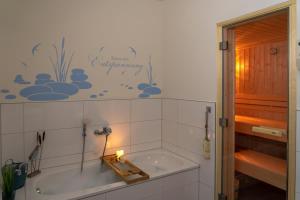 a bath tub in a bathroom with a candle in it at Ferienhaus SONNENWEG 16 in Heringhausen +15 photos