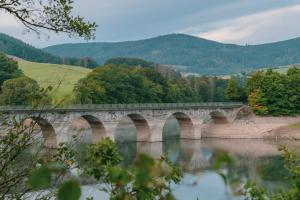 a bridge over a river with trees in the background at Ferienhaus SONNENWEG 16 in Heringhausen
