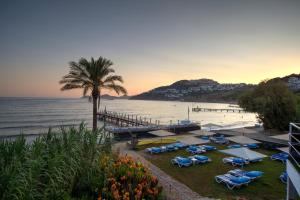 a beach with a bunch of umbrellas and the ocean at Crystal Hotel Bodrum in Gumusluk