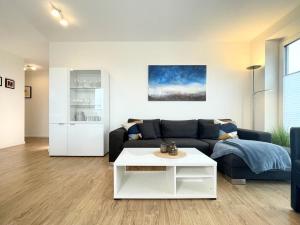 un soggiorno con un divano e un tavolo di Quartier Hohe Geest 2 a Sahlenburg