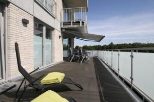 una terrazza con sedie e tavoli sul balcone di Quartier Hohe Geest 2 a Sahlenburg