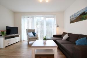 a living room with a couch and a table at Quartier Hohe Geest 14 in Sahlenburg