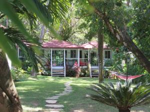 een huis met een hangmat in het midden van een tuin bij Bungalow Natura Village in Sosúa