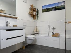 Un baño blanco con inodoro y lavabo. en Diemelblick 2 - TINNA, en Heringhausen 23 fotos más