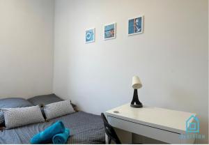 a bedroom with a bed and a desk with a lamp at Morska Water Massage Room 4 in Gdynia