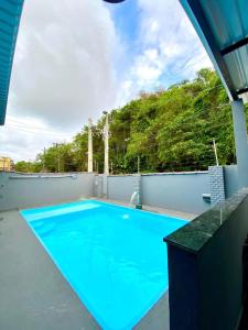 ein großer blauer Pool auf dem Dach in der Unterkunft Mar Suites Tenório in Ubatuba