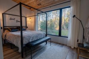 una camera con letto a baldacchino e ampia finestra di Brand New Black Fox Cabin with Private Nordic Spa a Sprucedale