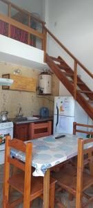 a kitchen with a table and chairs and a refrigerator at El nuevo amanecer mar de ajó in Mar de Ajó
