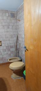 a bathroom with a toilet and a plunger in it at El nuevo amanecer mar de ajó in Mar de Ajó +2 photos