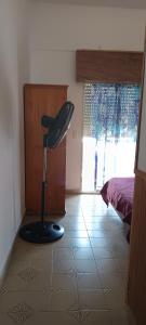 a room with a chair in the corner of a bedroom at El nuevo amanecer mar de ajó in Mar de Ajó