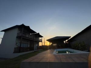 a house with a swimming pool next to a building at Encanto da Barra Pousada in Barra Grande