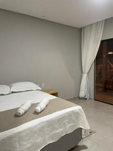 a bedroom with a bed with white towels on it at Encanto da Barra Pousada in Barra Grande +18 photos