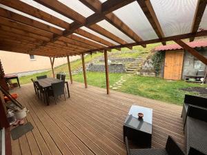 a large wooden deck with a table and chairs at Cozy 5 room house in Drienovská Nová Ves